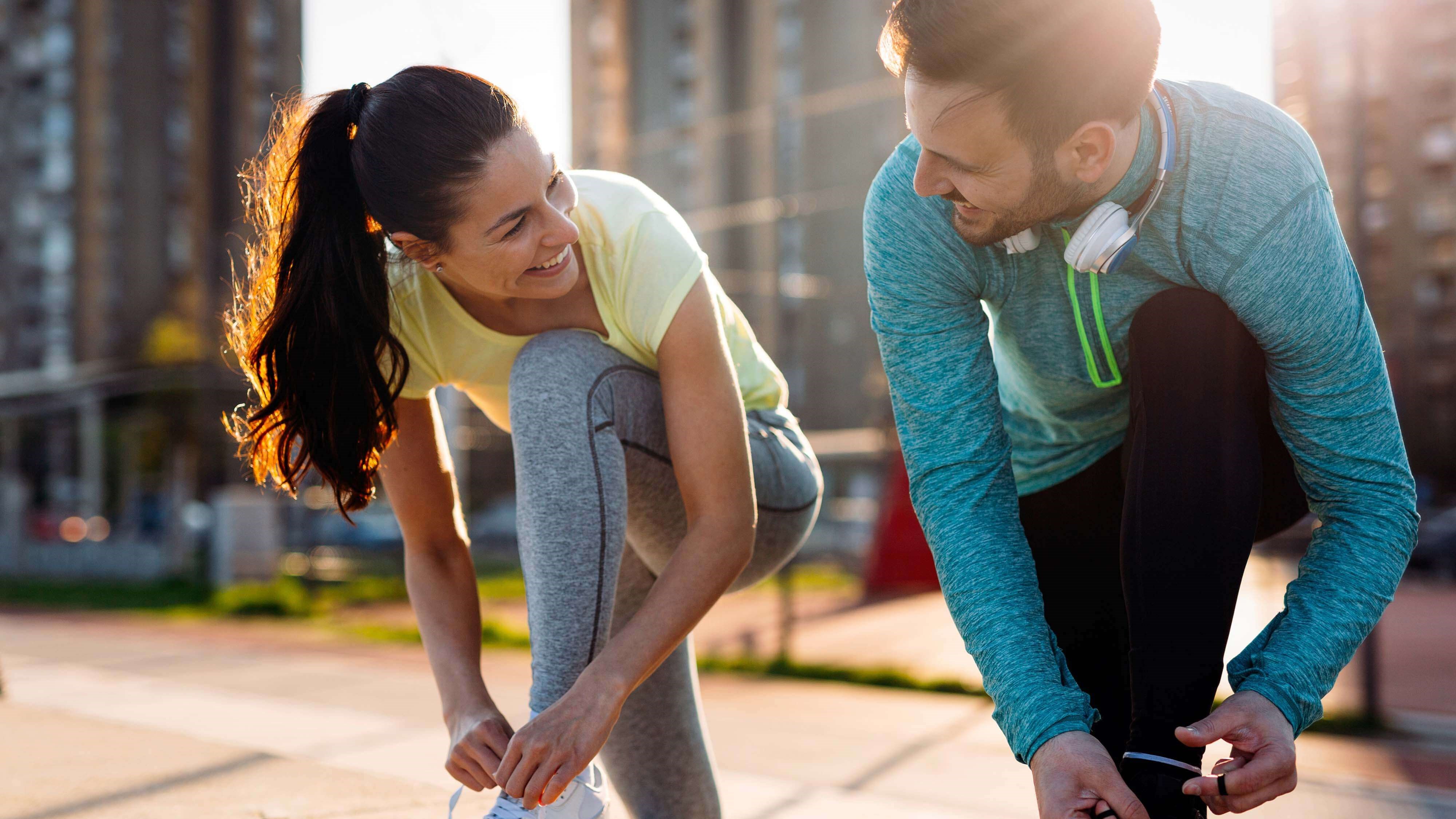 Man and woman lacing up shoes
